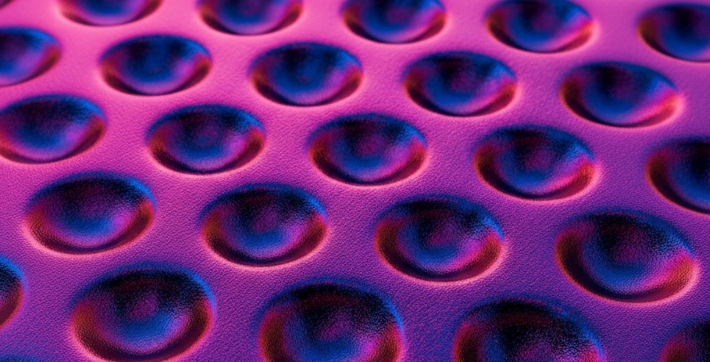 A Textured Surface With A Repeating Pattern Of Circular Indentations, Shimmering In Iridescent Hues Of Pink, Purple, And Blue